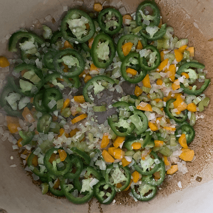 In a medium-large dutch oven or pot (4qt+), saute the onion, carrot, celery, and jalapeño in **2 tablespoons butter** over medium heat until soft, about 8-10 minutes, stirring regularly. Add in **3 cloves minced garlic** and saute for 1 minute longer, careful not to burn the garlic. Mix in **2 tablespoons flour**, coating the vegetables and mixing until no more raw flour is visible. The less time you cook the flour at this step the more thickening power the flour will have.